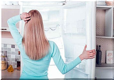 A woman in front of her freezer.