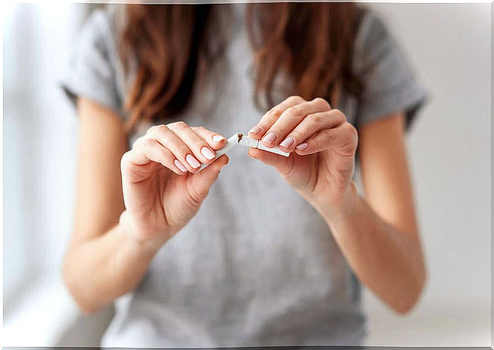 A woman who breaks a cigarette in half.