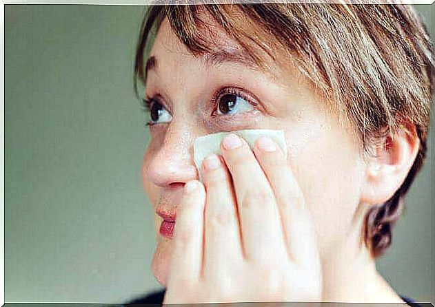 A woman cleaning her eyelids.